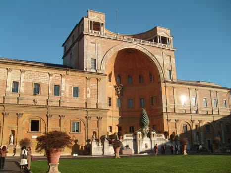 St. Peter, Vatican City. Vatican, December 10, 2019. Vatican courtyard. Tourists walk and sightseeing. Green grass on the lawn and blue sky.