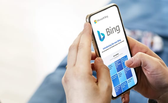 Redmond, US, Feb 2023: Female hands holding a phone with the Microsoft Bing website on the screen. Interior shot. Bing is a search engine recently integrated with AI chatbot. Illustrative editorial
