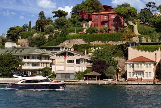 View from Bosphorus strait of the green mountains of the Asian side, with traditional houses and dense trees in a summer day, Istanbul, Turkey