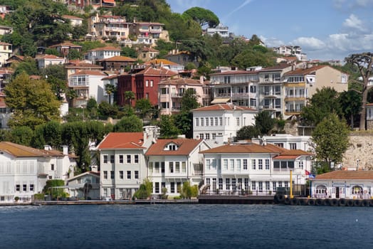 View from Bosphorus strait of the green mountains of the Asian side, with traditional houses and dense trees in a summer day, Istanbul, Turkey