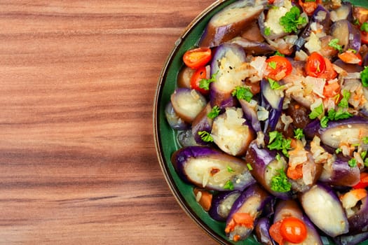 Warm purple eggplant, tomato and garlic salad. Salad of baked vegetables. Copy space for text