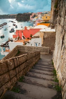 View of the Port of Corricella with lots of colorful houses on a sunny day in Procida Island, Italy.