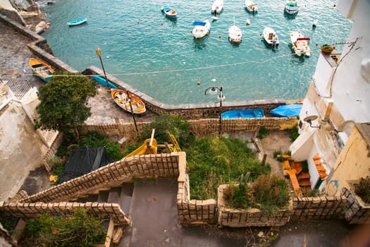 View of the Port of Corricella with lots of colorful houses on a sunny day in Procida Island, Italy.
