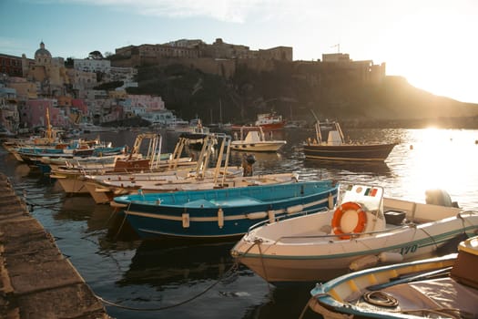 View of the Port of Corricella with lots of colorful houses on a sunny day in Procida Island, Italy.