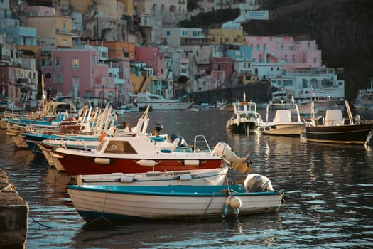 View of the Port of Corricella with lots of colorful houses on a sunny day in Procida Island, Italy.