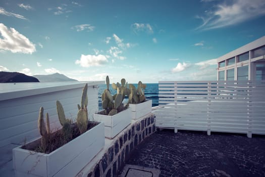Cozy terrace on the beach, idyllic view of the seashore. Tropical summer vacation concept.