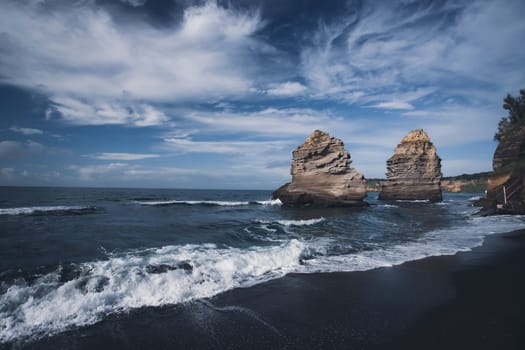 The black Ciraccio beach with the rock formations shaped by the wind on the northwest coast of the island of Procida in the Gulf of Naples