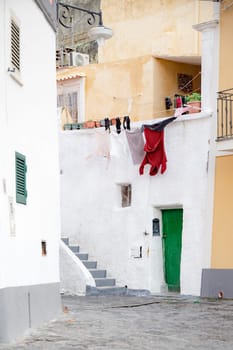 View of the Port of Corricella with lots of colorful houses on a sunny day in Procida Island, Italy.