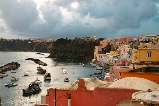 View of the Port of Corricella with lots of colorful houses on a sunny day in Procida Island, Italy.