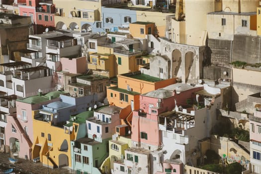 View of the Port of Corricella with lots of colorful houses on a sunny day in Procida Island, Italy.