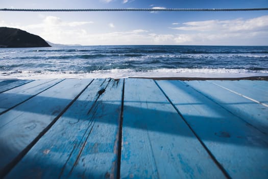 Empty white wood table top on blur abstract sea beach background with sunlight, for montage product display and mockup