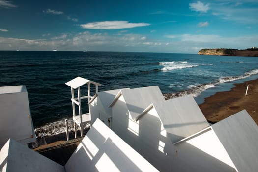 Traditional white wooden beach huts on the beach of Ciraccio, Procida island, Italy