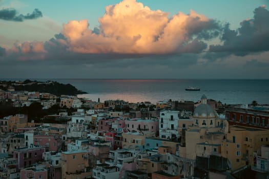 View of the Port of Corricella with lots of colorful houses in the sunset in Procida Island, Italy.