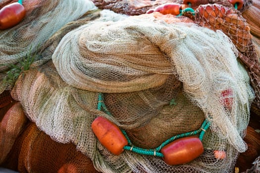 Fishing nets the Port of Corricella with lots of colorful houses on a sunny day in Procida Island, Italy.