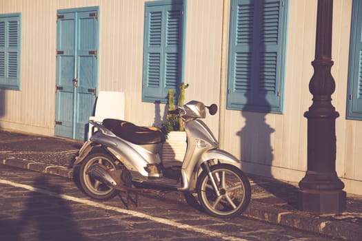 Typical street scene in Procida with an old scooter on a narrow cobblestoned street.