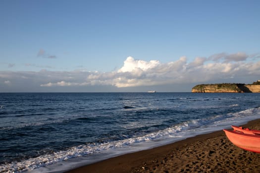 View of Ciraccio beach with black sand and clear water, Procida, Italy