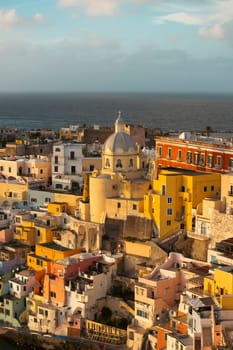 View of the Port of Corricella with lots of colorful houses in the sunset, Procida Island, Italy.