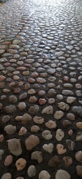 Paving stones made of round light stones similar to marble. Paved square in the old town of Sarajevo, Bosnia and Herzegovina. Beautiful wet shiny stones after rain. Close-up in natural daylight.