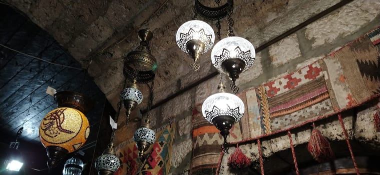 Traditional vintage Turkish lamps over light background in the night. Colored glass lamps and shades on the market in Sarajevo, Bosnia and Herzegovina. Sale of souvenirs in the market. Euro-trip.