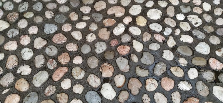 Paving stones made of round light stones similar to marble. Paved square in the old town of Sarajevo, Bosnia and Herzegovina. Beautiful wet shiny stones after rain. Close-up in natural daylight.