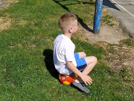 Sremska Mitrovica, Serbia. June 6, 2020. Sports games on the sports ground in the summer. The child plays with a ball. Schoolboy boy playing basketball during summer holidays