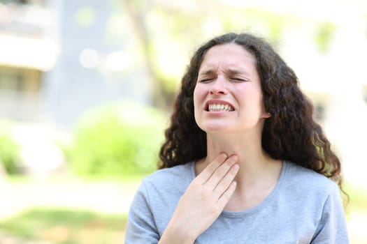 Woman suffering sore throat complaining in the street
