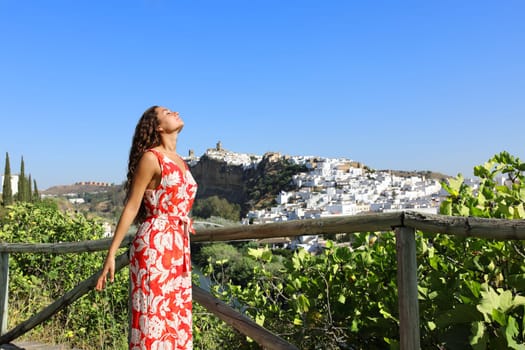 Profile of a tourist relaxing breathing fresh air on summer vacation in a town outskirts
