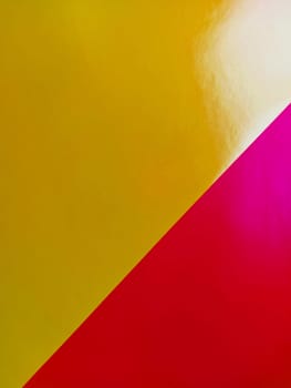 Yellow-pink bright background. Diagonally laid sheets of colored paper with a gradient and light flare.