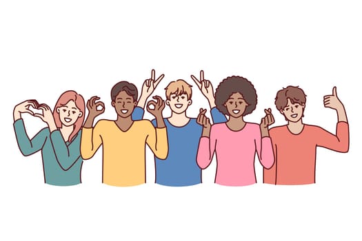 Team of diverse people of different genders and ages or nationalities pose together for group shot. Multiracial people working or studying in same team smiling and showing friendly gestures