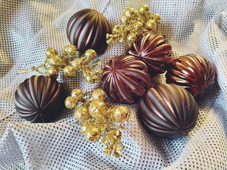 Beautiful New Year or Christmas composition of Christmas tree decorations, balls and golden twigs. Silvery background with holes. Soft focus. New Year and Christmas background or postcard