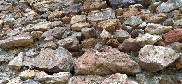 Stone wall. Stacked large cobblestones in warm colors. Tower in Kula, Serbia