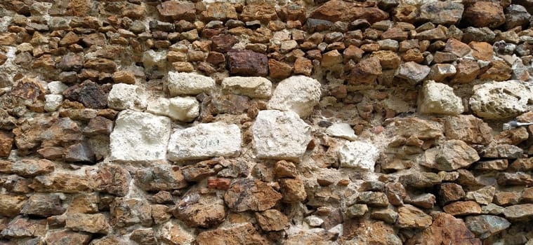 Stone wall. Stacked large cobblestones in warm colors. Tower in Kula, Serbia