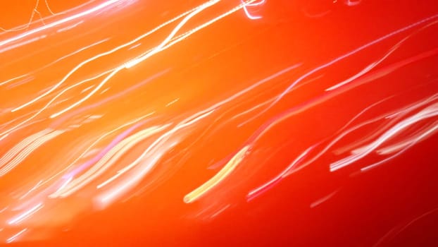 Bright red-orange background with traces of headlights, lights or rays of light. White and yellow dashes and strokes.