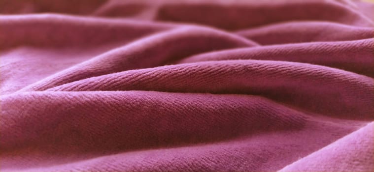 Pink velvet is folded by beautiful waves. Retro style. Soft pleasant fabric for sewing clothes, items for the interior, for upholstery. Soft focus.