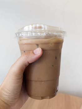 Hand holding glass of iced coffee mocha, stock photo