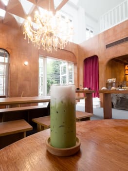 Iced matcha greentea on wooden table in coffee shop, stock photo