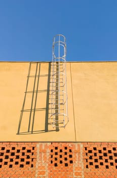 fixed Service ladder installed on a commercial premises under construction. Blue sky background
