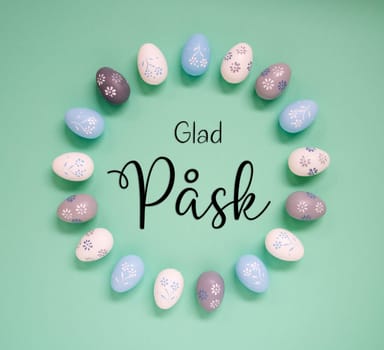 Flat Lay With Swedish Text Glad Pask Means Happy Easter. Easter Egg Arrangement, Decoration And Ornament. Light Green Paper Background