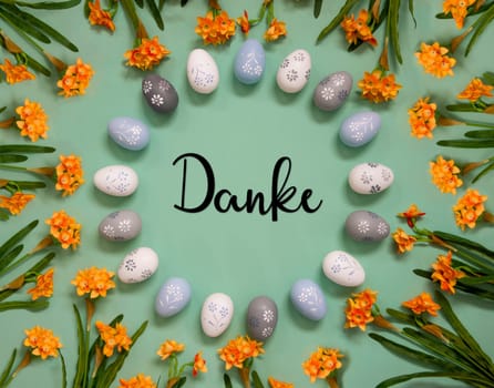 Flat Lay With German Text Danke Means Thank You. Easter Egg Decoration With Orange Spring Flowers. Light Green Paper Background.