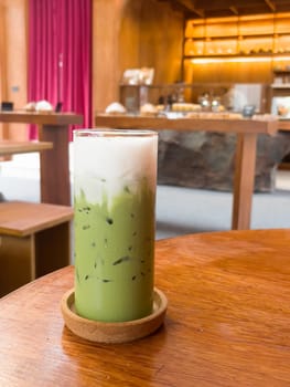 Iced matcha greentea on wooden table in coffee shop, stock photo