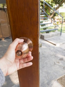 Hand on metal door holder, stock photo