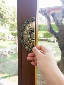 Hand on metal door holder, stock photo