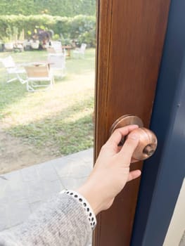Hand on metal door holder, stock photo