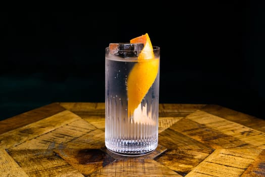 Stemmed cocktail glass with alcoholic drink, closeup isolated on black. Template design
