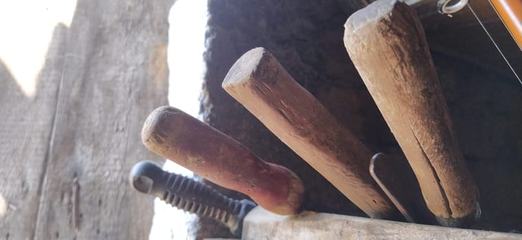 old farming tools at walls of the house. barn tool handles.