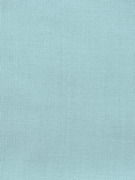 texture of natural light green or blue fabric close-up. The texture of the fabric is made of natural cotton or linen textile material. Green canvas background. Smooth surface of mint-colored fabric.