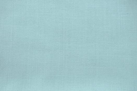 texture of natural light green or blue fabric close-up. The texture of the fabric is made of natural cotton or linen textile material. Green canvas background. Smooth surface of mint-colored fabric.