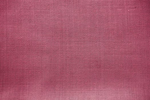Cloth close-up. Interlacing of threads. A piece of pink fabric. Fabric background. Copy space.