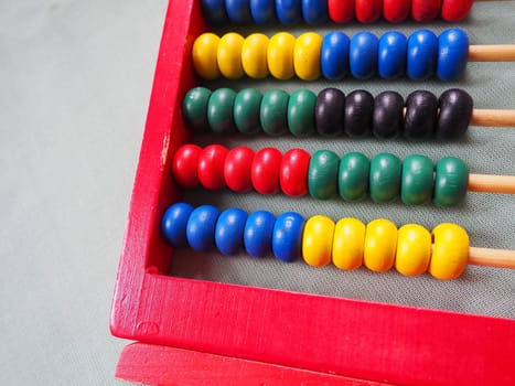 Education concept - abacus with many colorful beads. Red, blue, green, black, yellow details on the abacus. Mathematical exercises. School program.
