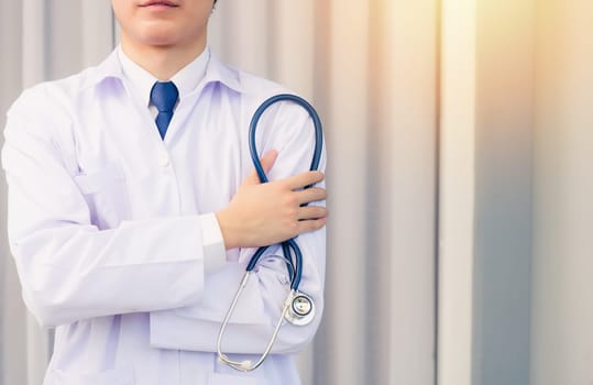 Doctor Day. Nurse man smiling in uniform stand crossed arm hold doctor stethoscope on hand looking to camera with cop space, Healthcare medicine insurance concept